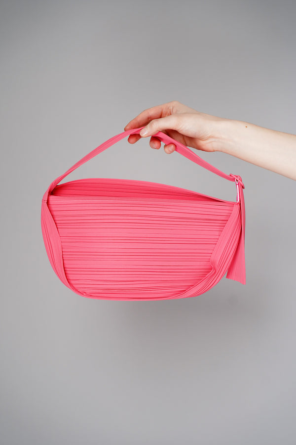 Pleats Please Issey Miyake Half Moon Bag in Neon Pink Vancouver. Shop Online or in Store.